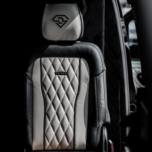 Rear-facing bench seat with flip-down centre armrest and cup